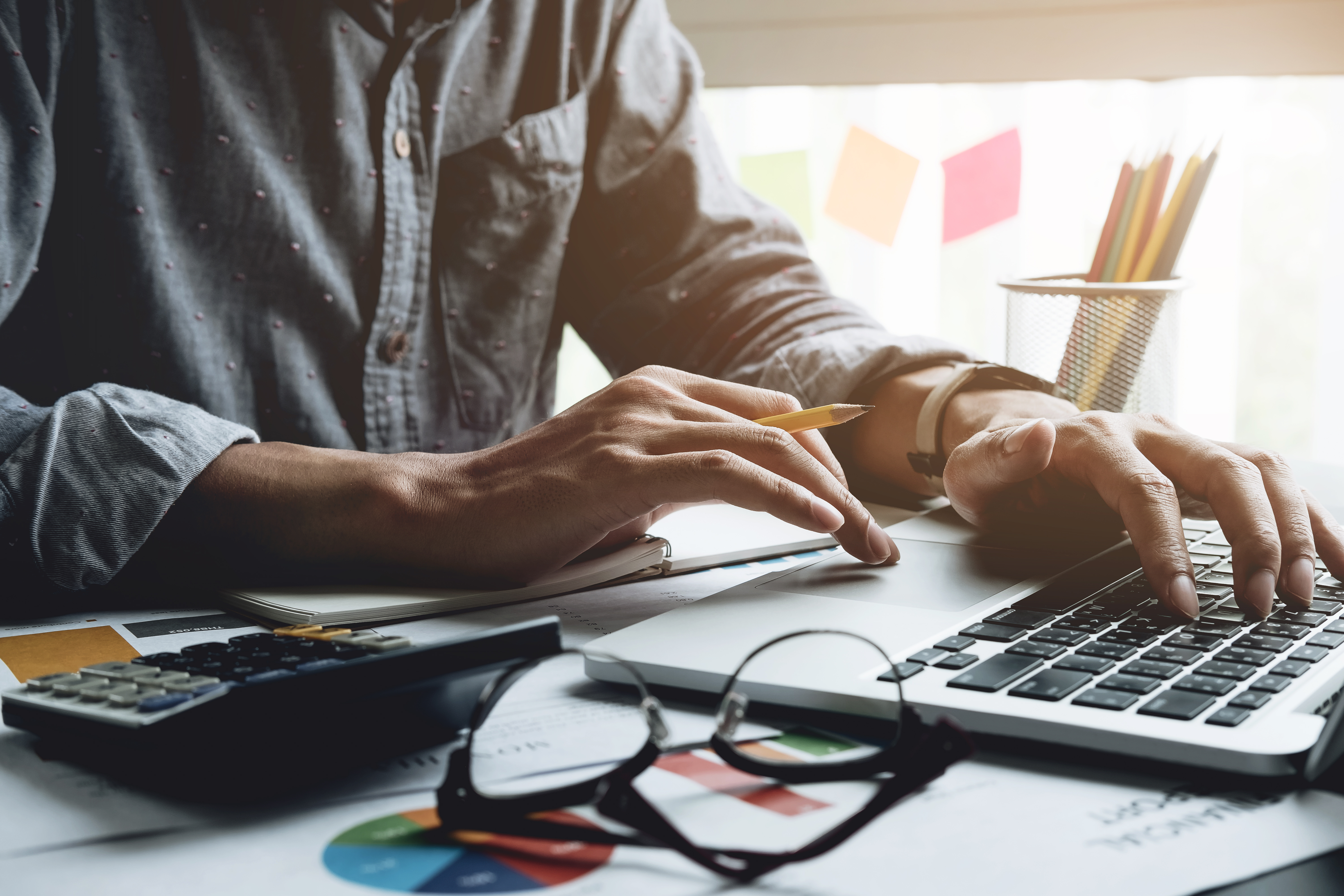 An image with of a man doing taxes at a kitchen table on free tax software.