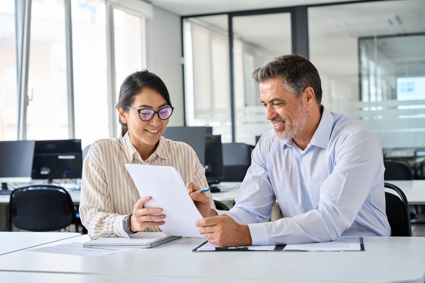 Two people looking over tax information - Paramount Tax and Accounting.